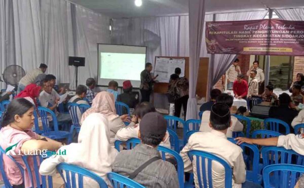 Proses rekapitulasi manual hasil Pilkada 2024 di Desa Sarirogo, Kabupaten Sidoarjo, oleh KPU, dengan saksi paslon turut hadir.