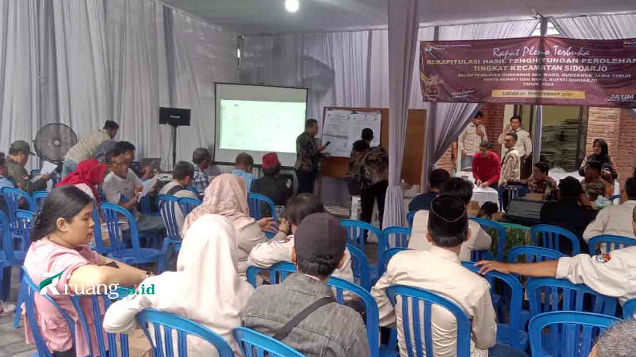 Proses rekapitulasi manual hasil Pilkada 2024 di Desa Sarirogo, Kabupaten Sidoarjo, oleh KPU, dengan saksi paslon turut hadir.