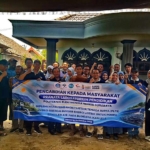 Tim PENS bersama peternak lele Desa Tunggorono di depan spanduk pengabdian masyarakat
