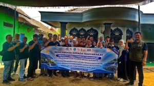 Tim PENS bersama peternak lele Desa Tunggorono di depan spanduk pengabdian masyarakat