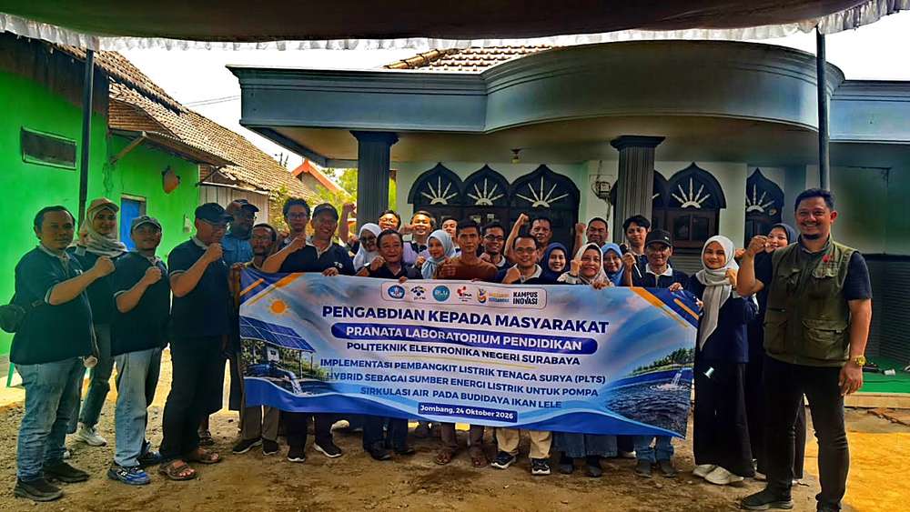 Tim PENS bersama peternak lele Desa Tunggorono di depan spanduk pengabdian masyarakat