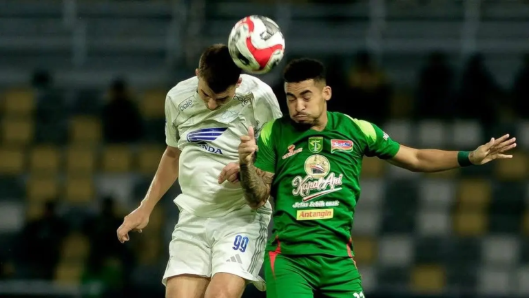 Pemain PSM Makassar Luka Cumic berduel udara dengan pemain Persebaya Surabaya dalam laga Super League