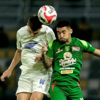 Pemain PSM Makassar Luka Cumic berduel udara dengan pemain Persebaya Surabaya dalam laga Super League